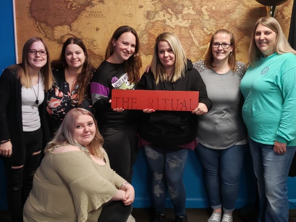 Group of friends celebrating after completing an escape room challenge at Worlds Away Escape in Winchester, Virginia